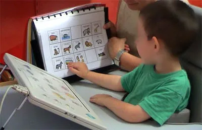 Alumno señalando en un tablero pictográfico